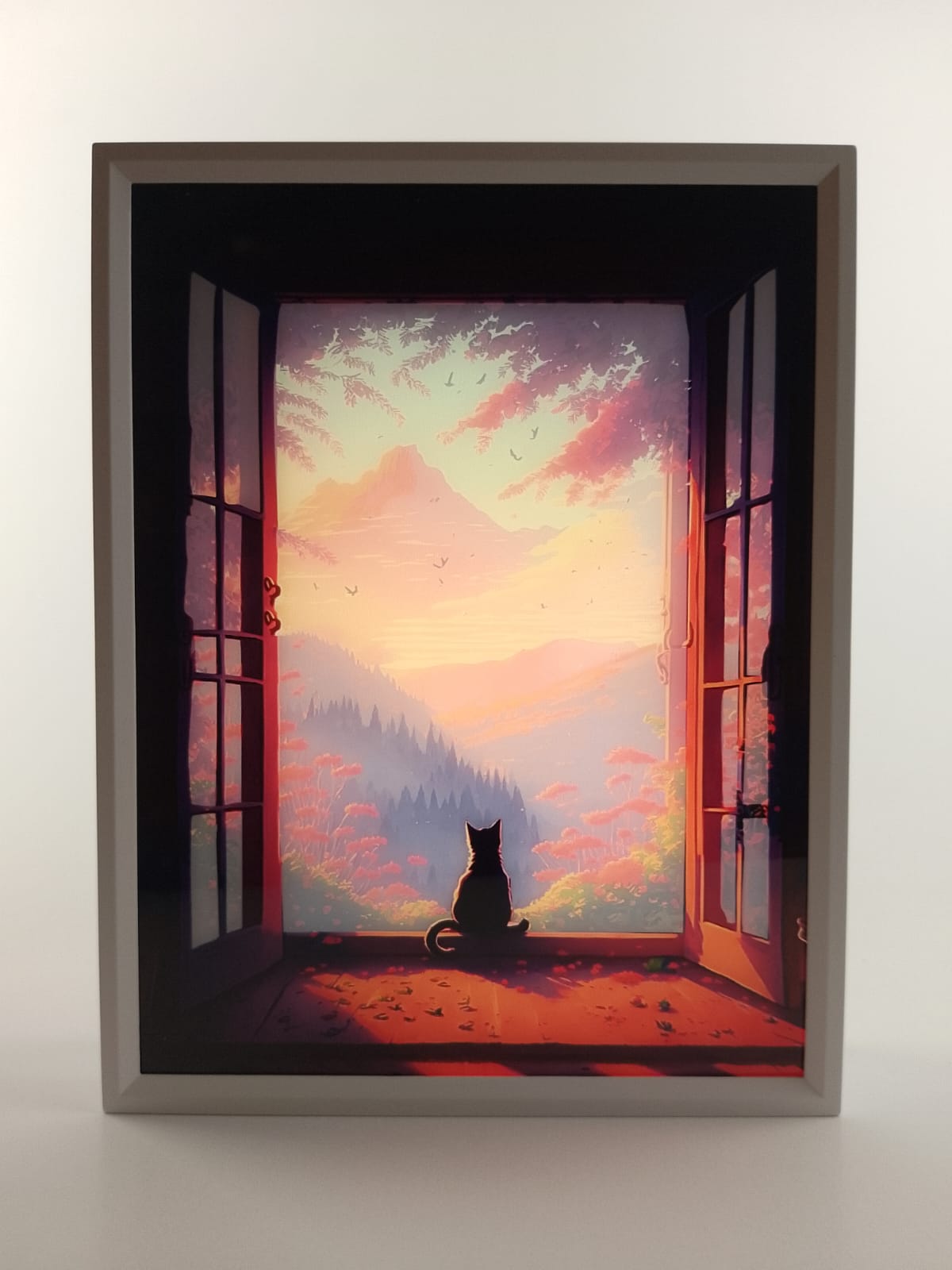 Twilight Watcher light-up window artwork in soft peach and rose sunset colors, with a cat looking toward the mountains